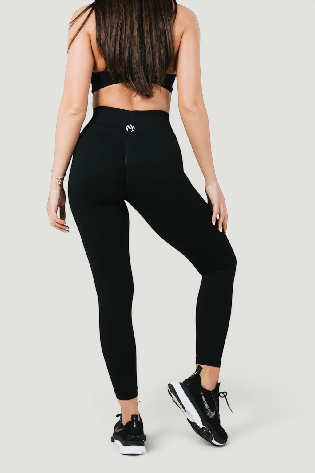 A N A M E black midnight high-waist leggings with sculpting fit and logo detail, worn by a model in a studio setting.