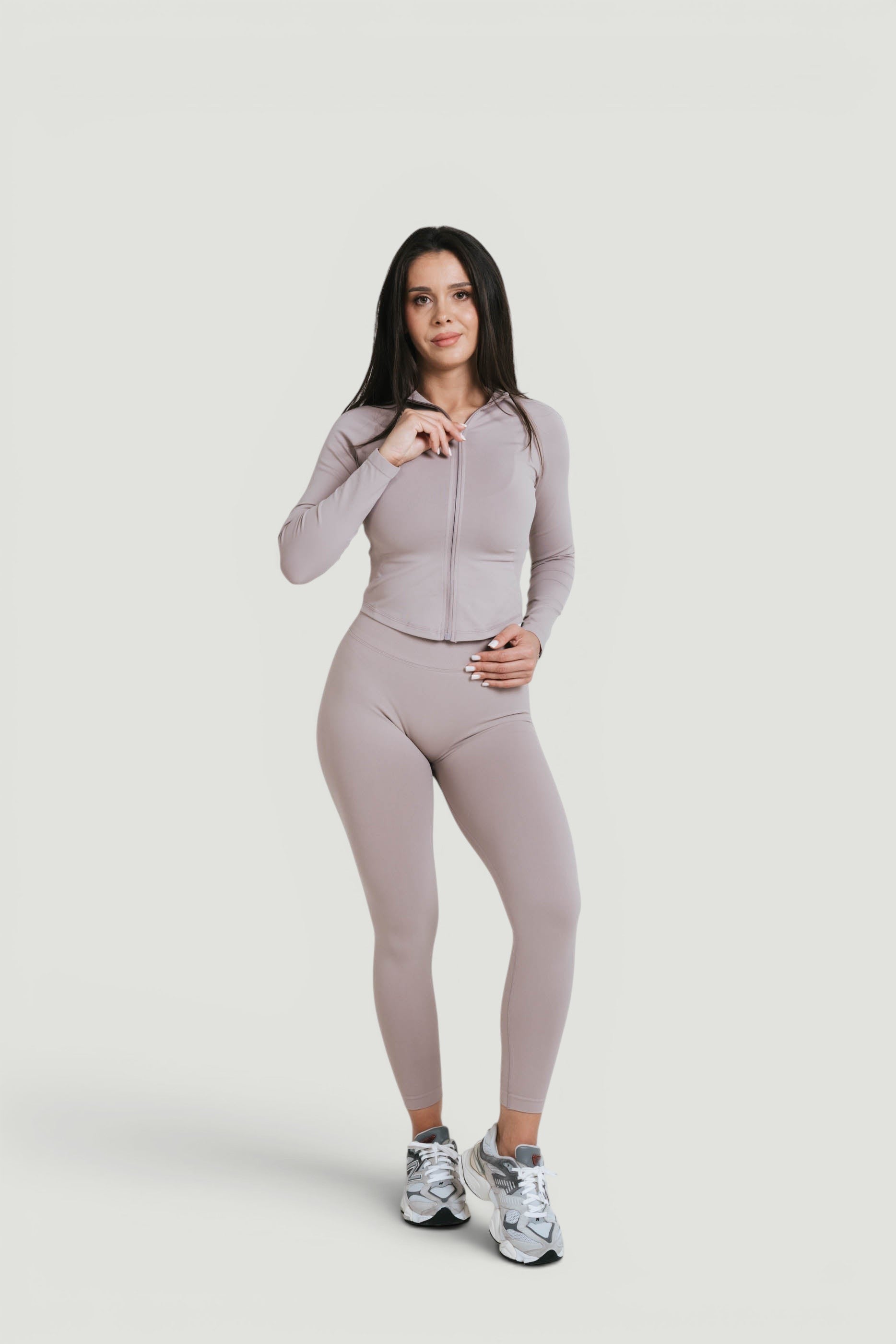 A N A M E Core Jacket in Mocha Cappuccino, worn by a model with matching leggings and sneakers for a versatile athletic look.