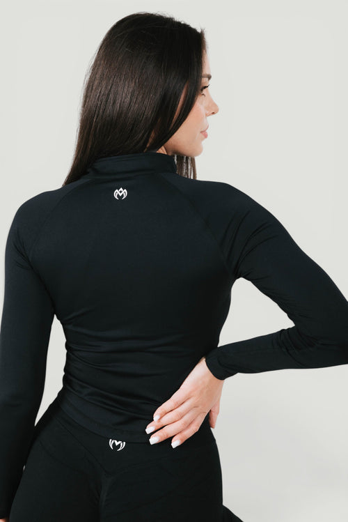 A N A M E Core Jacket in black, a long-sleeve performance top with a mock neck and subtle logo detail on the back.