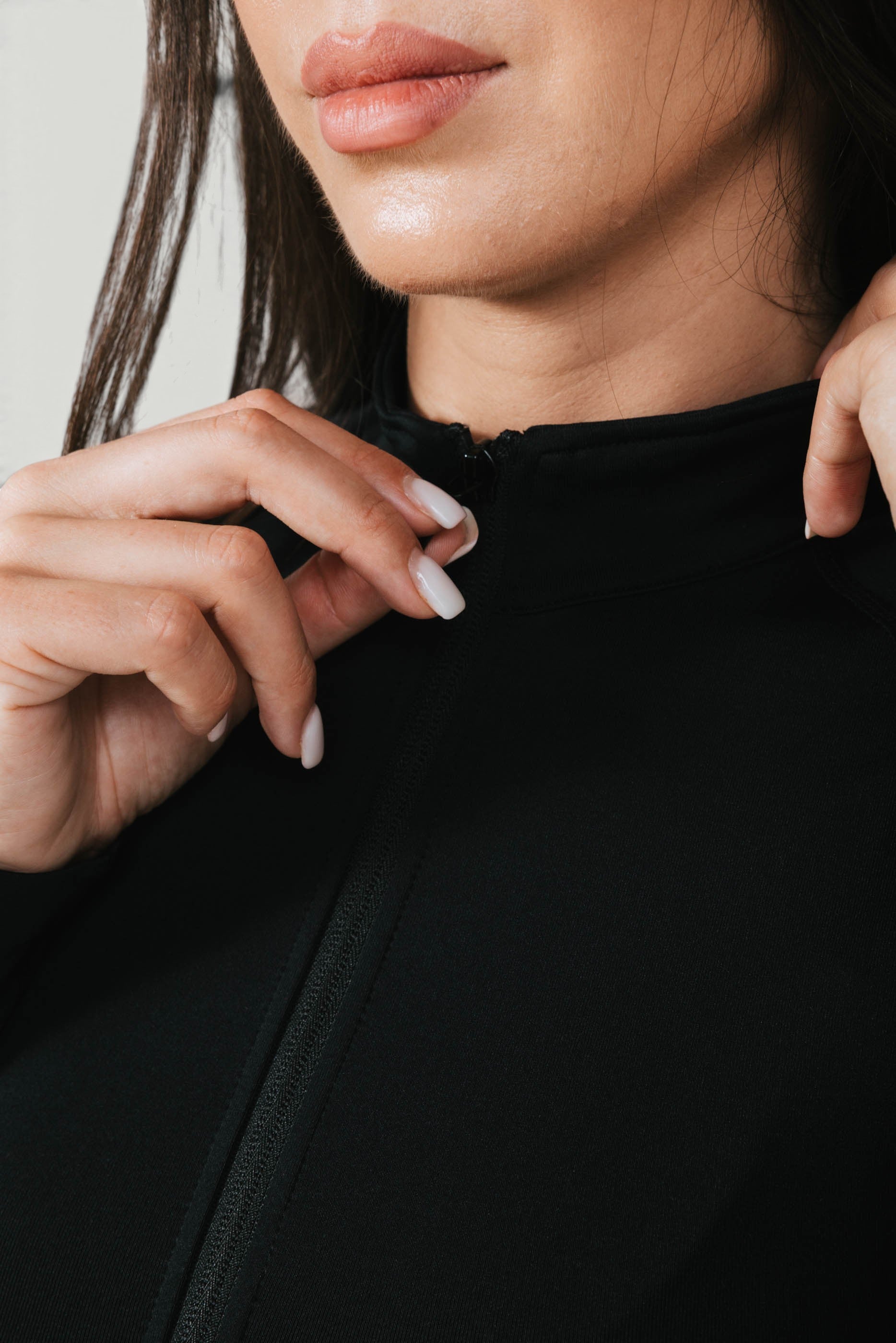 A N A M E Core Jacket in black, featuring a high-neck zip design for a feminine, performance-ready fit.