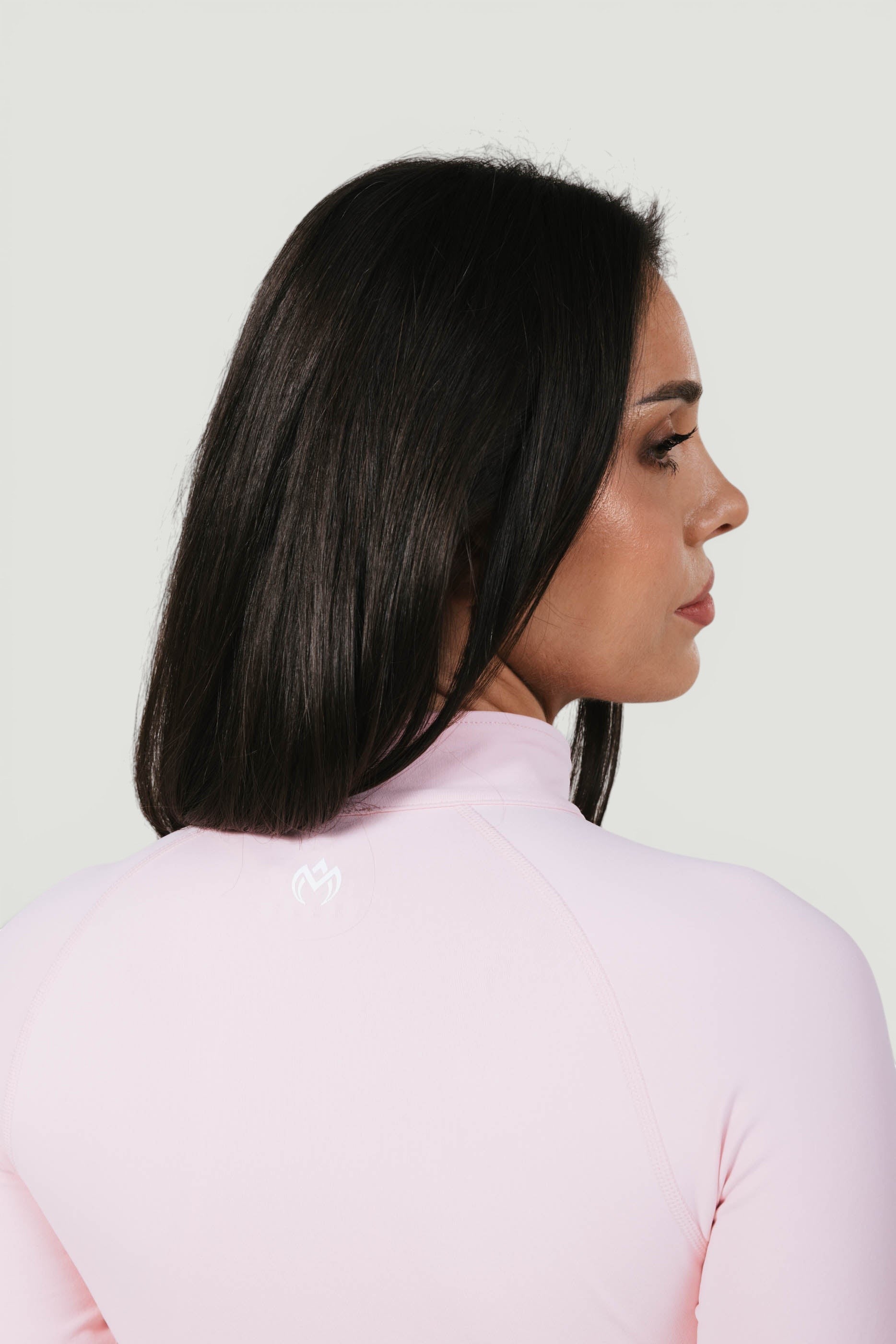 A N A M E Core Jacket in pink rose, featuring a mock neck and performance fabric on a model from the back.
