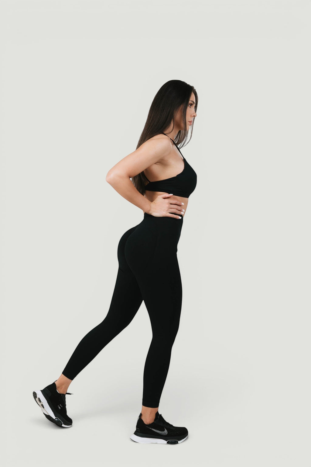 A N A M E high-waist black midnight leggings on a model, providing a sculpted fit and support for a refined athletic look.
