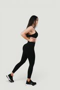 A N A M E high-waist black midnight leggings on a model, providing a sculpted fit and support for a refined athletic look.