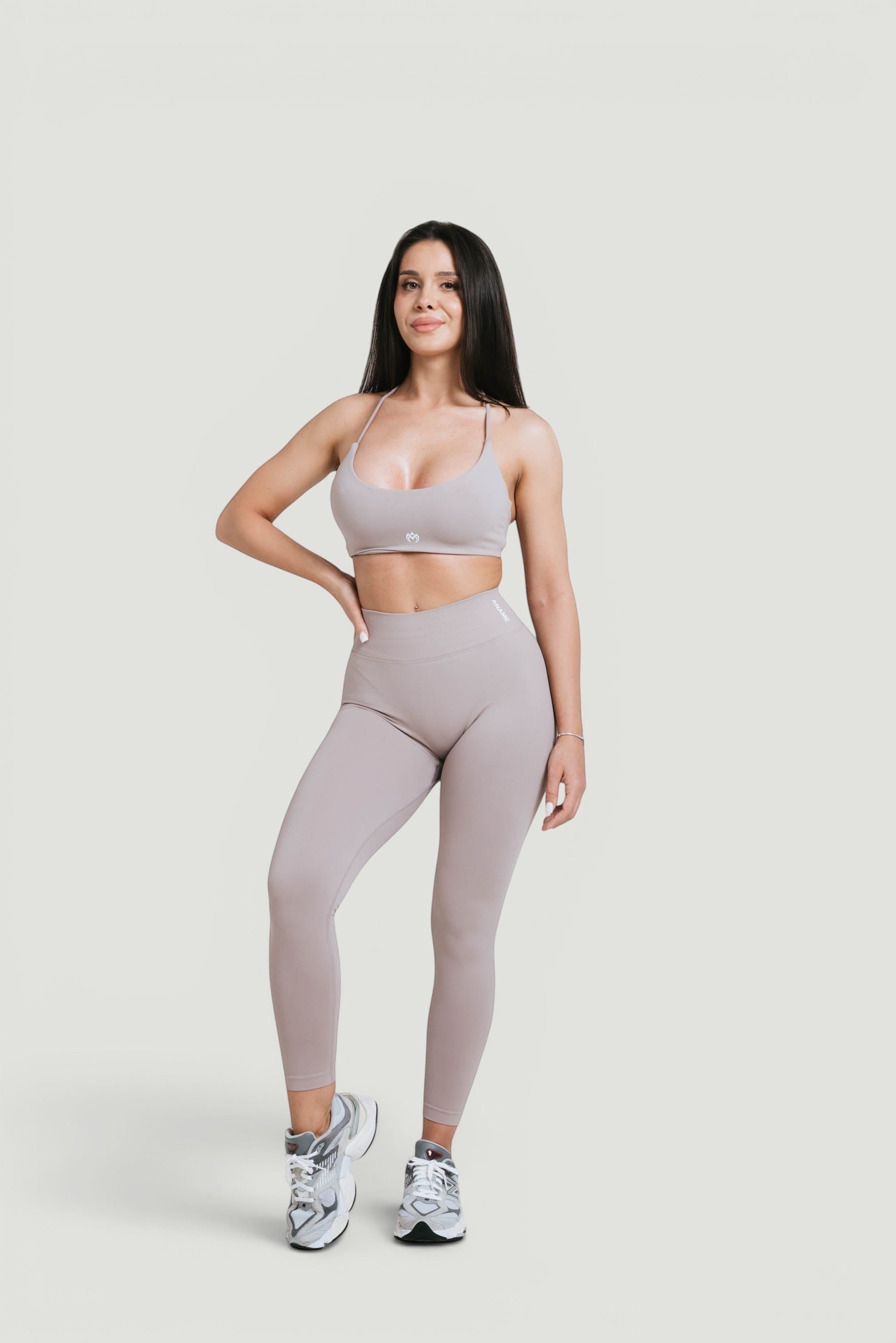 A N A M E high-waist Mocha Cappuccino leggings on a model, providing a sculpted, supportive fit for athletic wear.