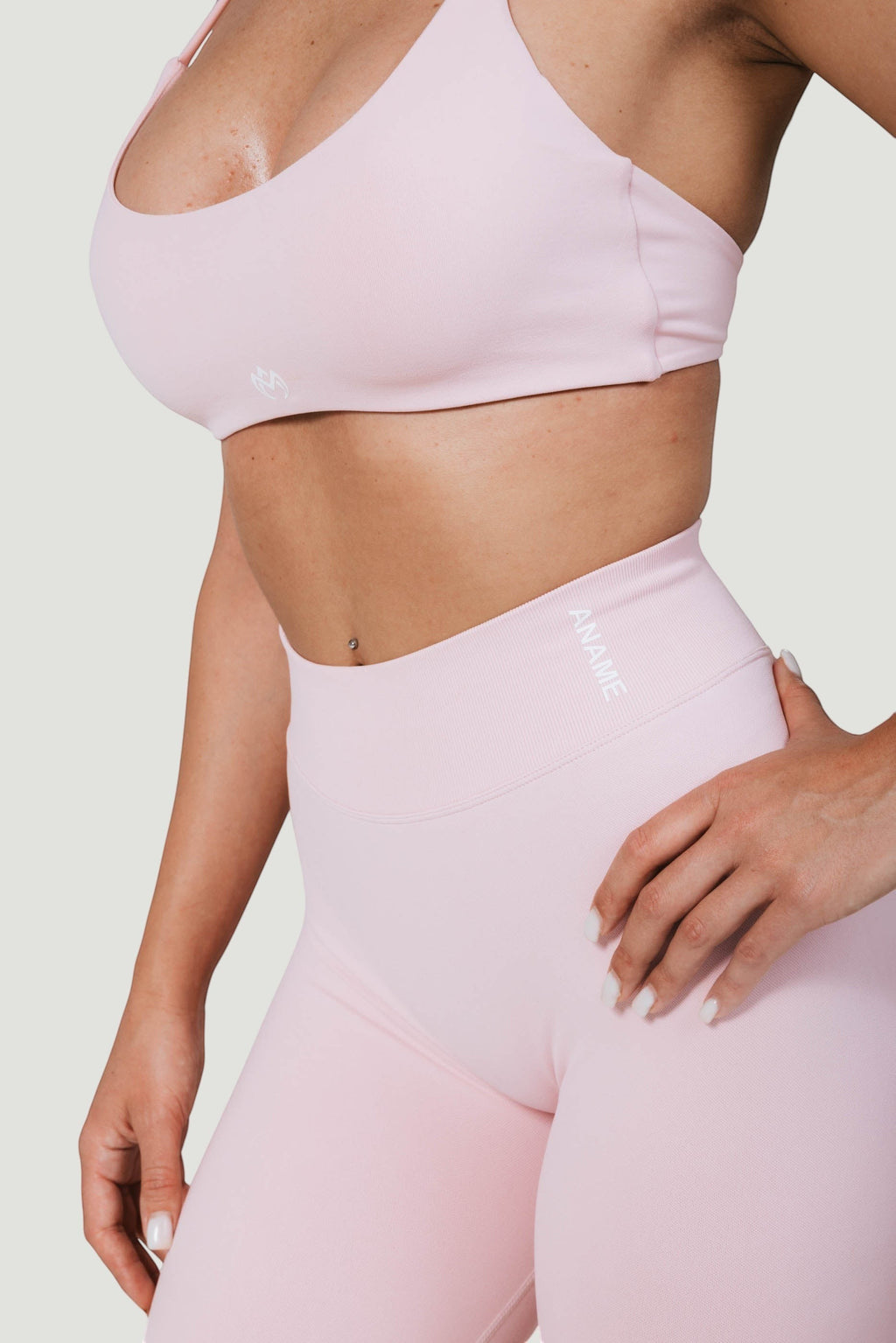 A N A M E high-waist pink rose leggings with a supportive, sculpted fit worn by a model in a matching sports bra.