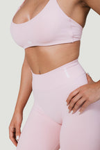A N A M E high-waist pink rose leggings with a supportive, sculpted fit worn by a model in a matching sports bra.