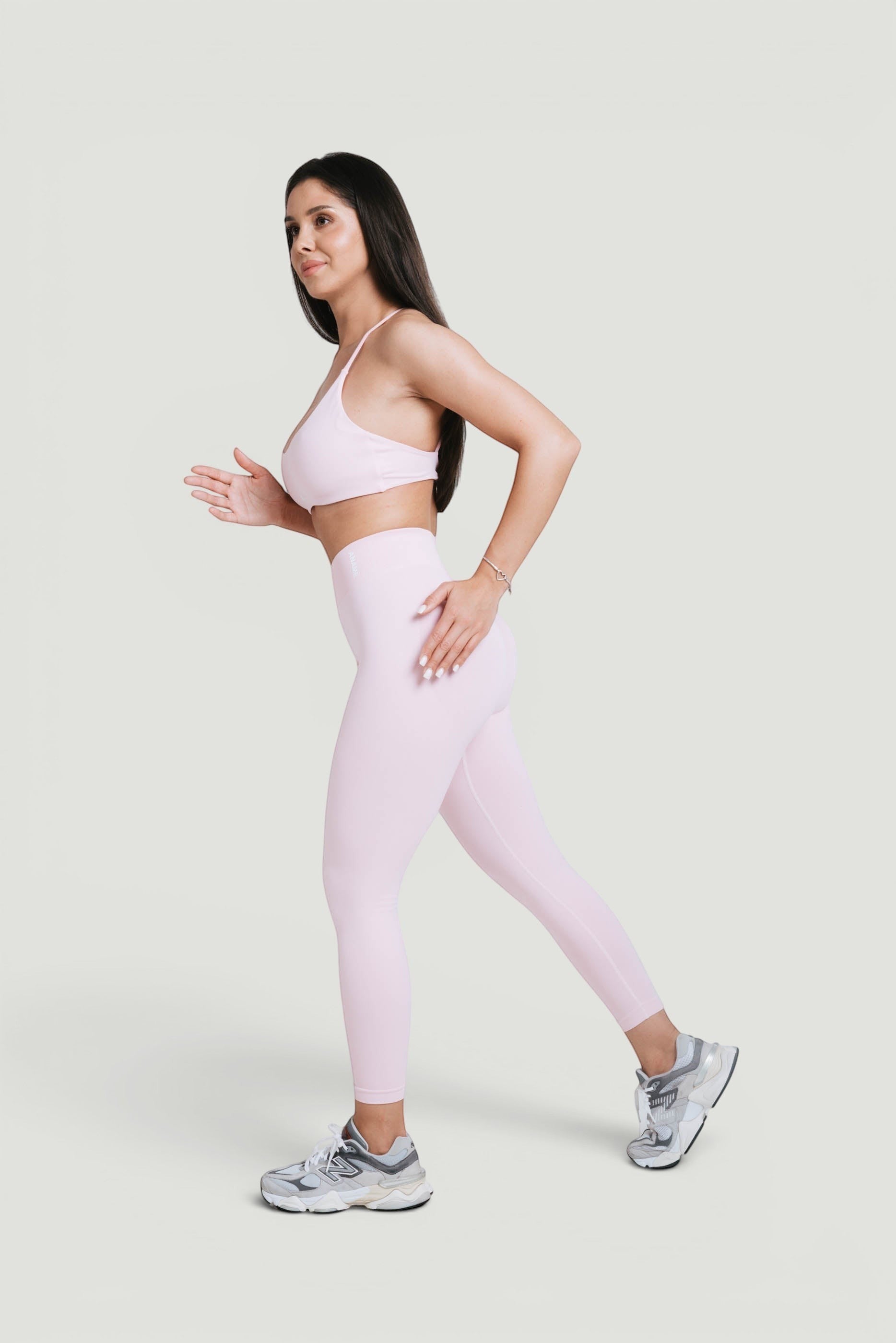 A N A M E high-waist pink rose leggings on a woman in a sports bra, offering a sculpted, supportive fit for workouts.
