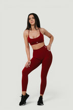 A N A M E high-waist red wine sculpting leggings worn by a model with a matching sports bra for a supportive athletic look.