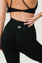 A N A M E black midnight high-waist leggings with a sculpted fit and subtle glute-defining seam detail on a fit model.
