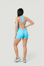 Model wearing A N A M E Frosted blue Motion Jumpsuit with open-back design and scrunch detail for workouts.