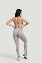 Model wearing A N A M E Mocha Cappuccino twisted-back sports bra and matching leggings for a workout.