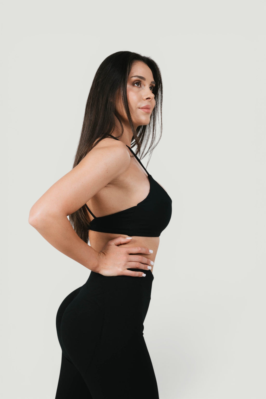 A N A M E black midnight Twisted-back Bra worn by a woman, featuring delicate straps and a feminine, supportive design.