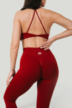 A N A M E red wine Twisted-back Bra with delicate straps worn by a woman with matching high-waisted leggings.