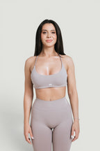 A N A M E Mocha Cappuccino sports with delicate straps and a twisted-back design worn by a model with matching leggings.