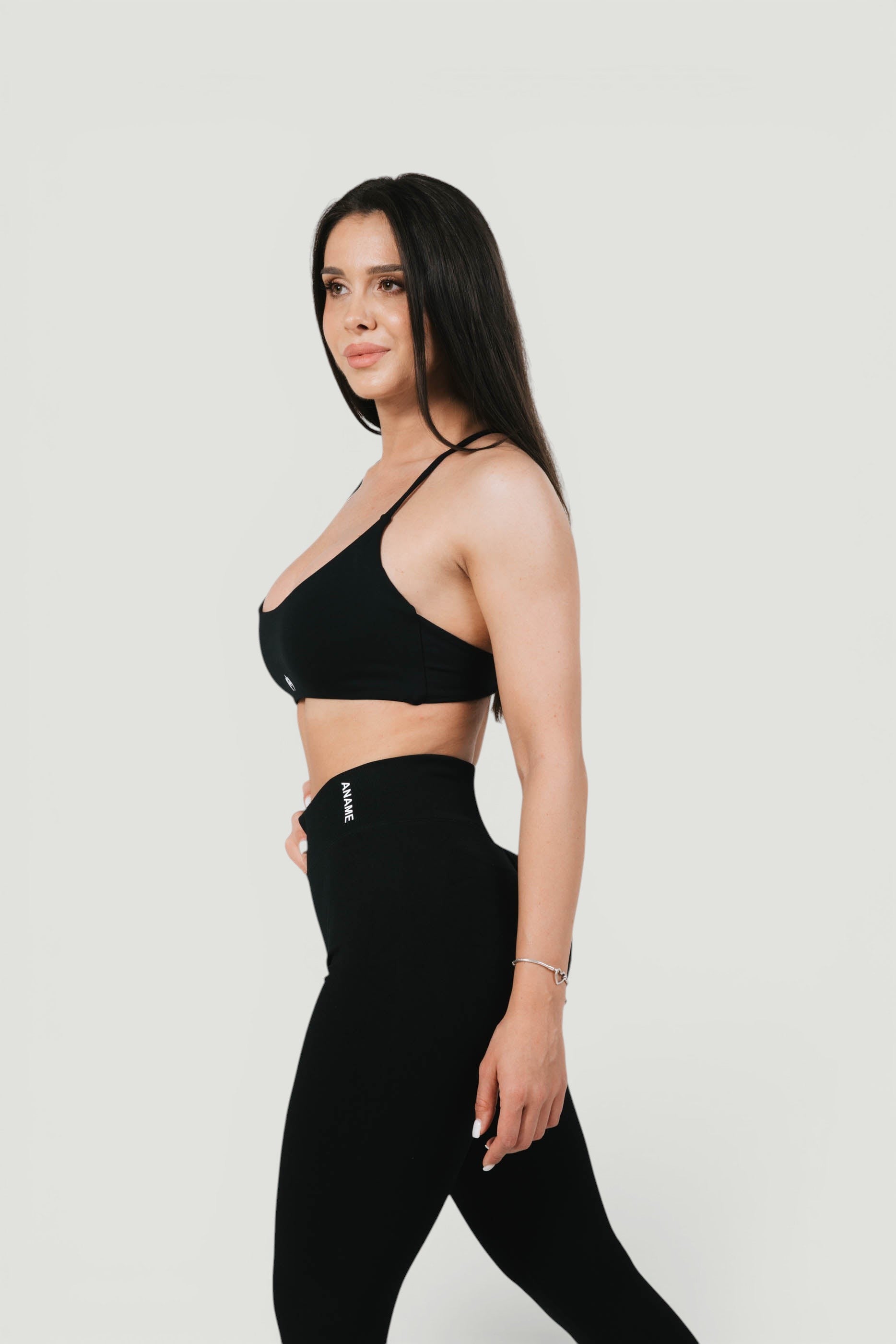 A N A M E black midnight Twisted-back Bra worn by a model, featuring delicate straps and a refined, supportive design.